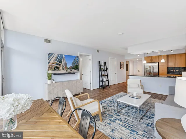 a living room with furniture and a dining table with wooden floor