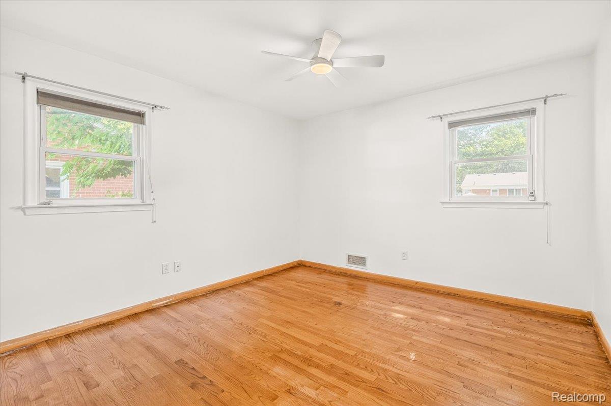 11802 Columbia Street Redford, MI 48239 - Photo 19 of 39 Bedroom 3 with Original Hardwood Floors in good condition, Vinyl Replacement Windows, a New Ceiling Fan, and Mirrored Closet Doors.