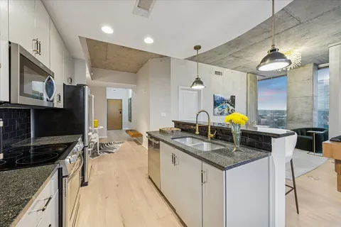 a kitchen with stainless steel appliances kitchen island granite countertop a refrigerator and a stove top oven