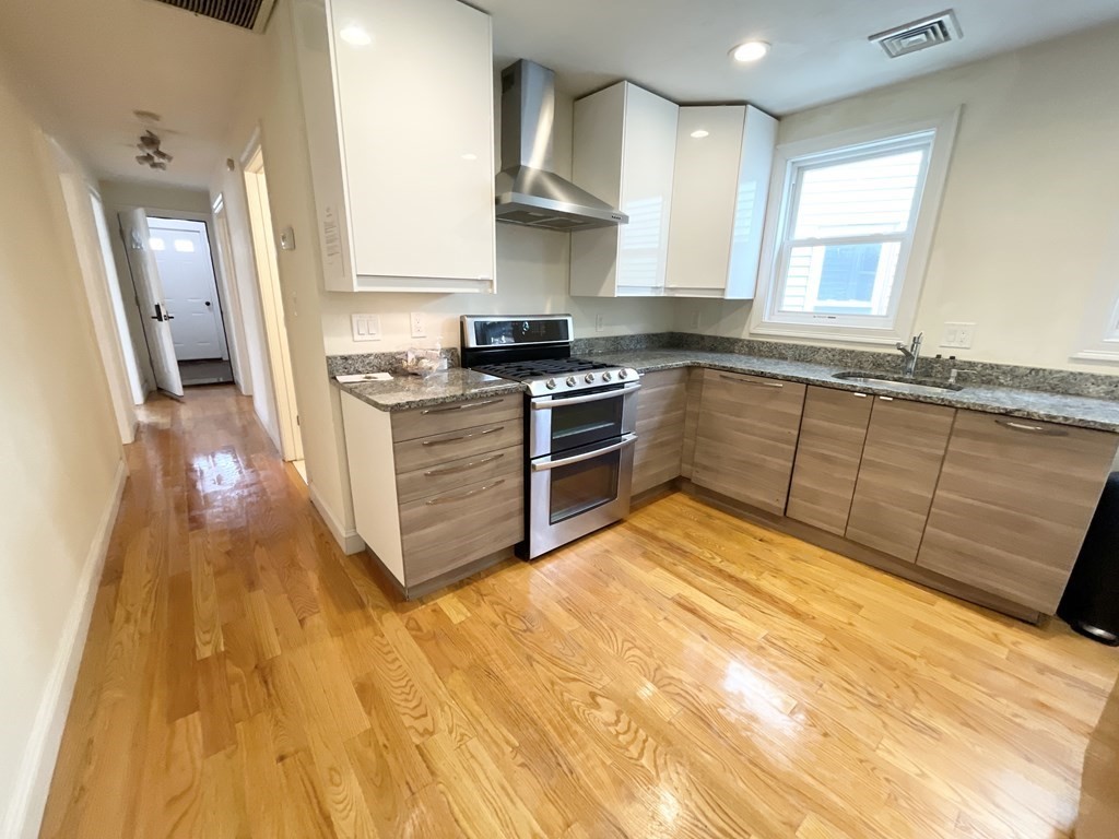 a kitchen with stainless steel appliances granite countertop a stove a sink and a refrigerator