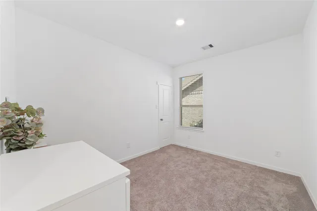 an empty room with windows and exposed radiator