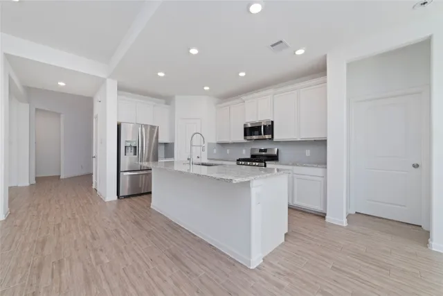 a kitchen with stainless steel appliances a refrigerator and a stove top oven