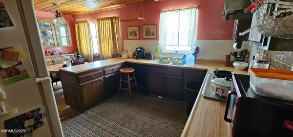 a kitchen that has a sink and chairs in it