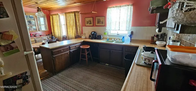 a kitchen that has a sink and chairs in it