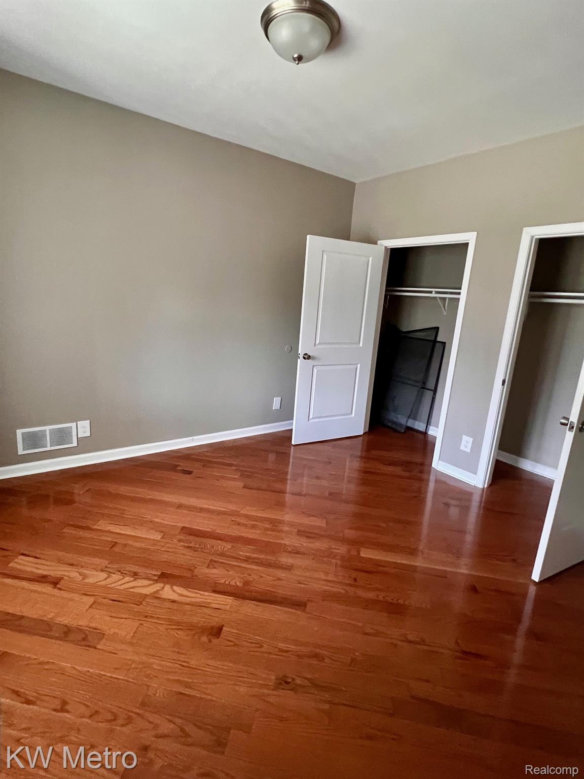939 Webb Street Detroit, MI 48202 - Photo 4 of 19 Hardwood flooring throughout featuring white baseboards, neutral wall tones, and overhead lighting