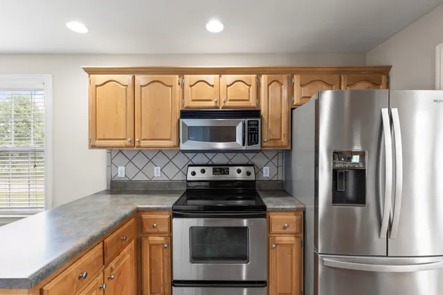 a kitchen with stainless steel appliances granite countertop a stove a refrigerator and a sink