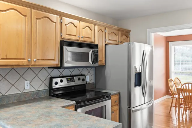 a kitchen with granite countertop a refrigerator and a stove top oven
