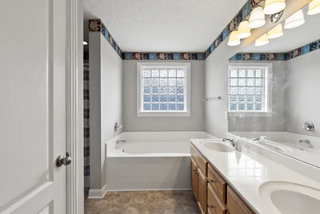 a spacious bathroom with sink shower and bathtub