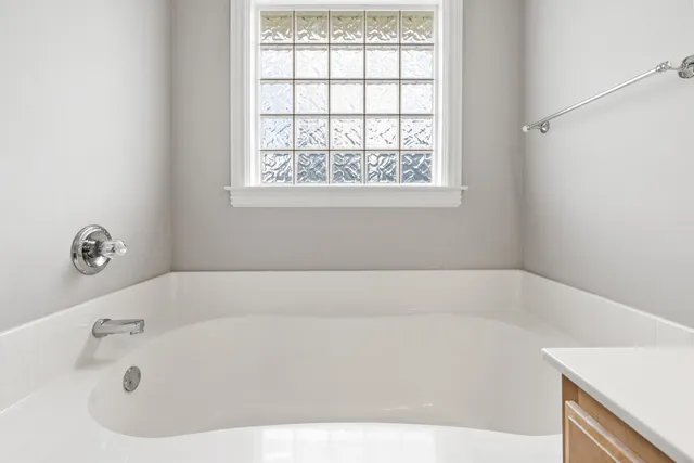 a white bath tub sitting in a bathroom next to a window