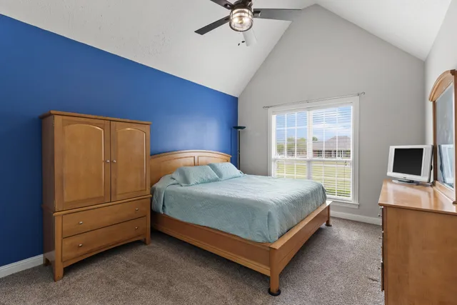 a bedroom with a bed and a flat tv screen next to a window