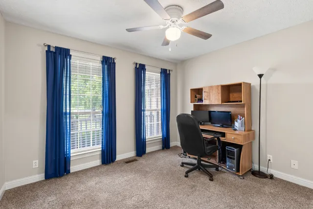 a view of a workspace with furniture and a window