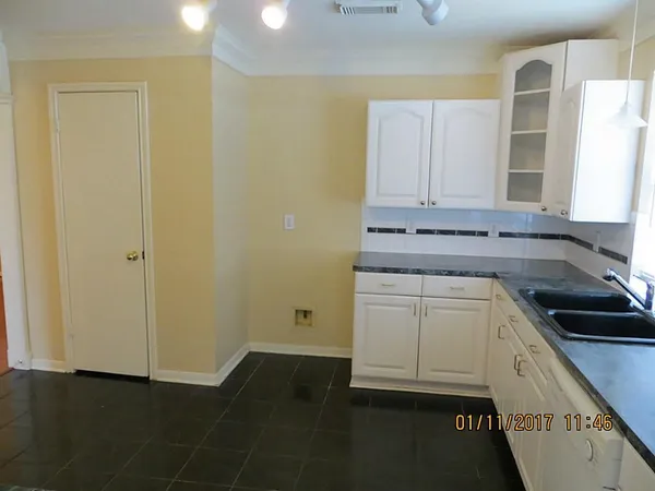 a kitchen with white cabinets and appliances