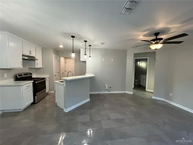 a view of a kitchen with a sink a kitchen counter space cabinets and stainless steel appliances