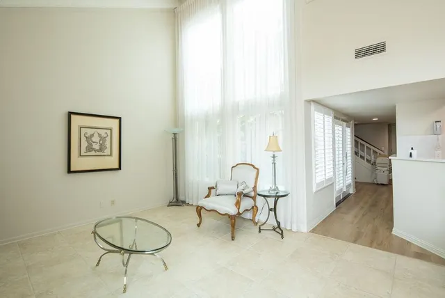 a living room with couches and a dining table with wooden floor