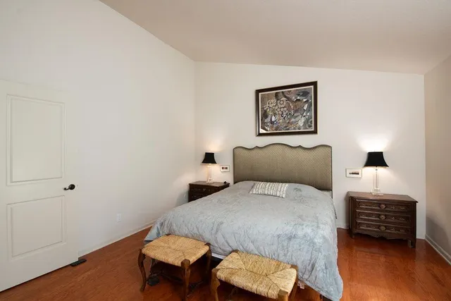 a bedroom with a bed a couch and a potted plant