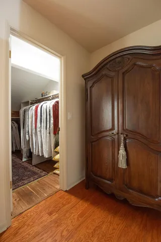 a view of walk in closet with clothes and shoes