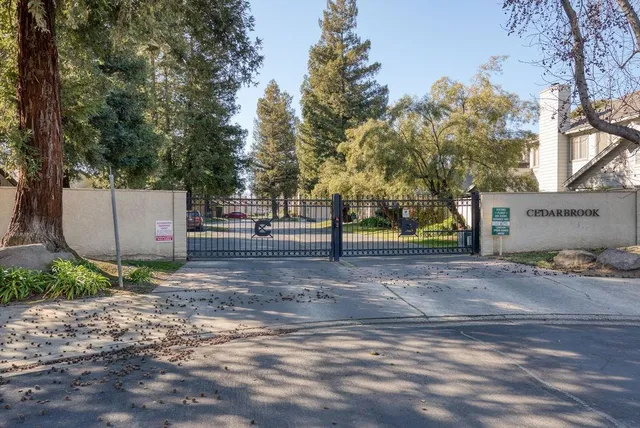 a view of a tennis ground with large trees