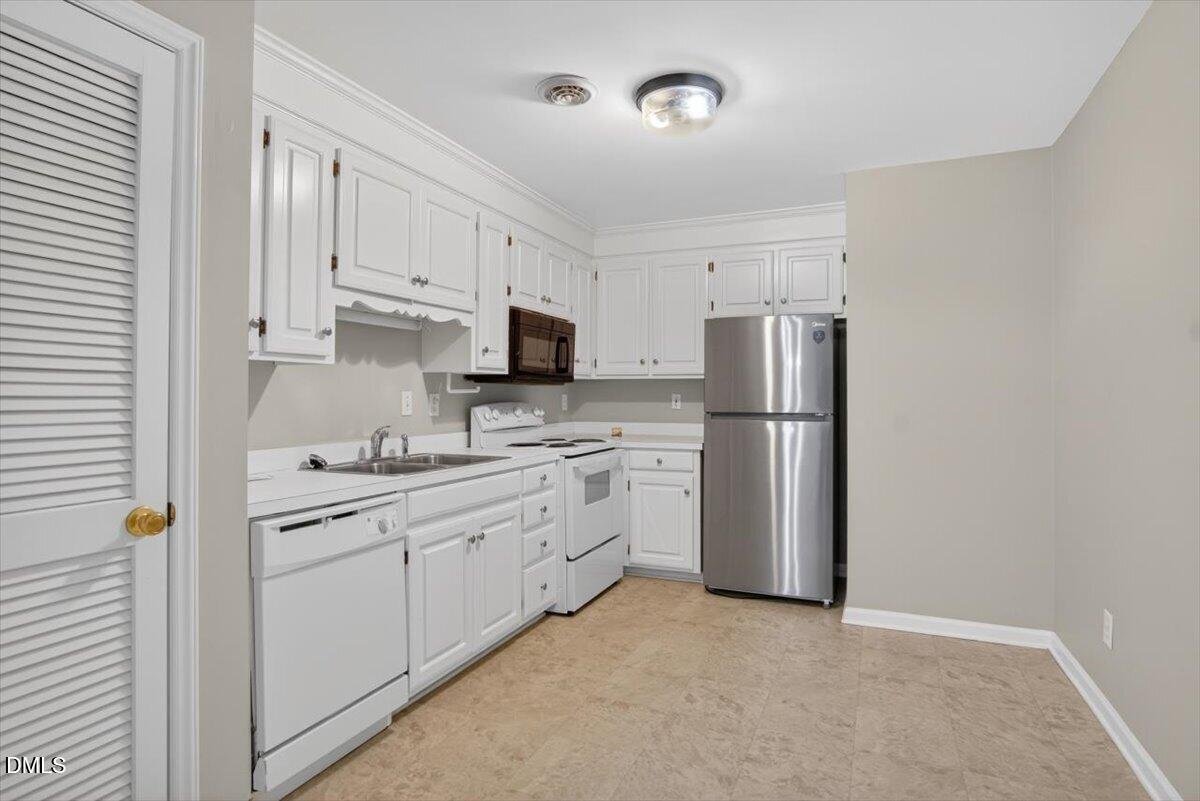 1630 Oxford Road, Unit B Henderson, NC 27536 - Photo 3 of 30 a kitchen with white cabinets and stainless steel appliances