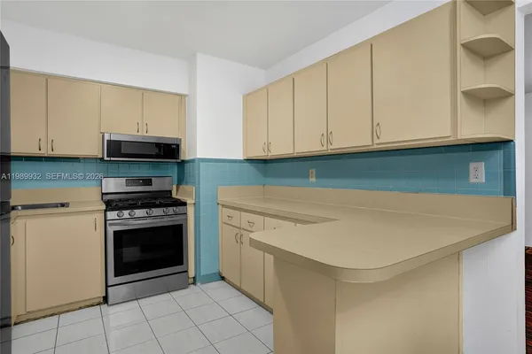 a view of a white house with a big yard and large tree