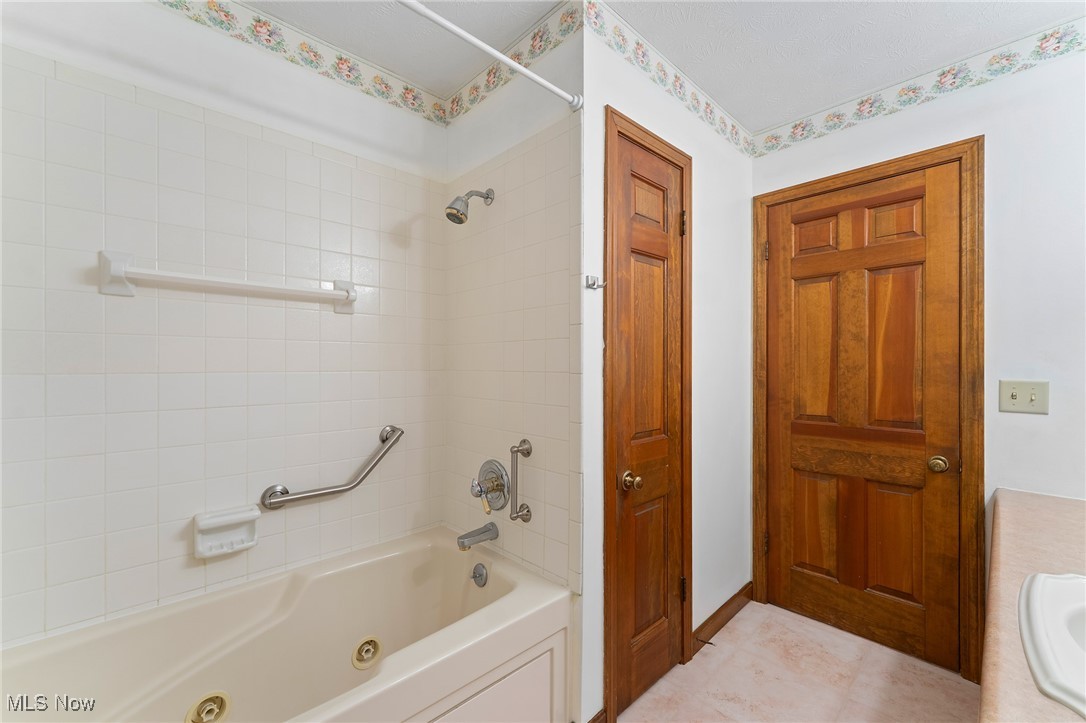 744 Johnson Plank Road Warren, OH 44481 - Photo 19 of 39 Bathroom with a combined bath / shower with jetted tub, vanity, and tile patterned floors