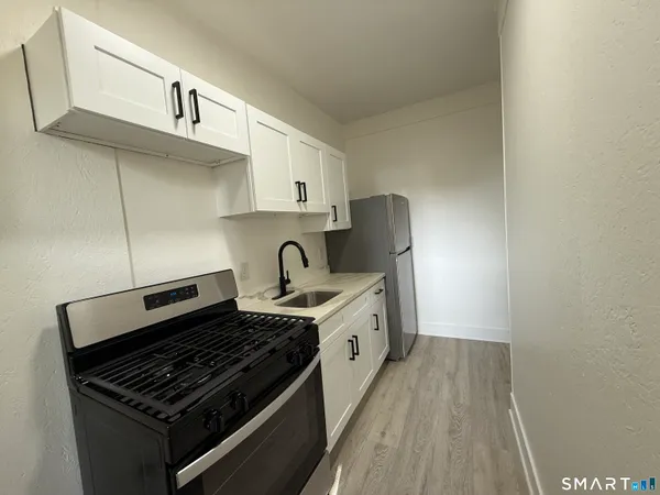a kitchen with granite countertop a stove and a sink