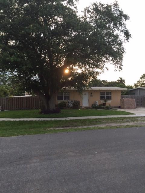 35 Tortuga Road Palm Springs, FL 33461 - Photo 2 of 17 a front view of a house with a garden and trees