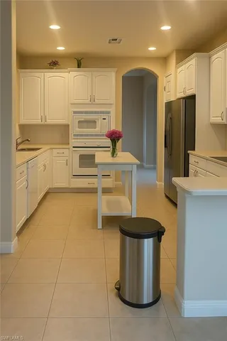 a kitchen with stainless steel appliances granite countertop a sink a stove and a refrigerator