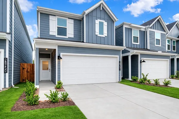 front view of a house with a yard and an trees