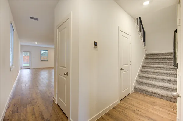 a view of a hallway with wooden floor and entryway