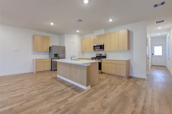 a view of kitchen with sink microwave and cabinets