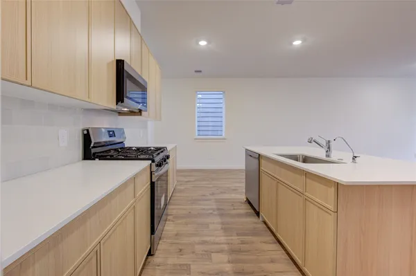 a kitchen with a sink stove and microwave