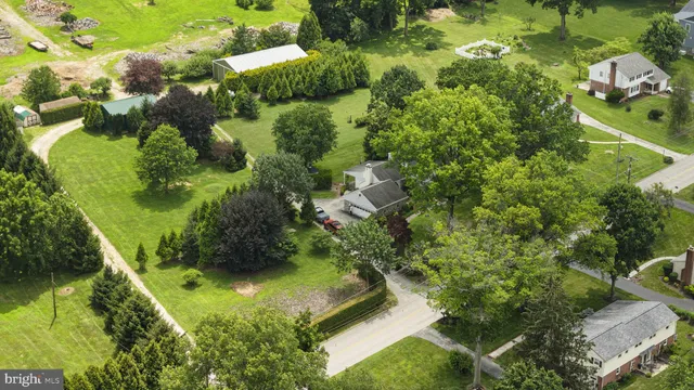 an aerial view of a residential houses with outdoor space and trees