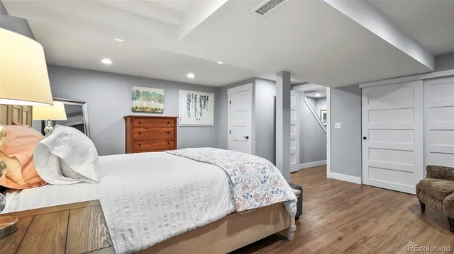 a spacious bedroom with a bed and wooden floor