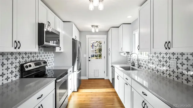 a large kitchen with a sink and stainless steel appliances