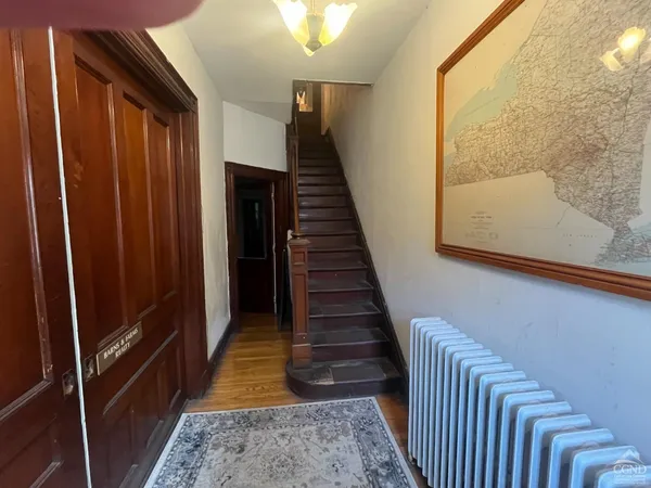 a view of a hallway with wooden floor and staircase