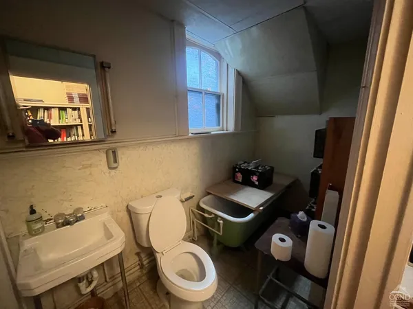 a bathroom with a sink a toilet and a window