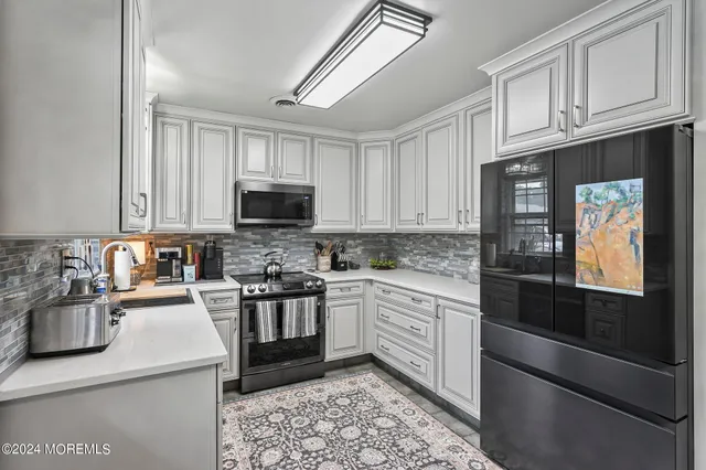 a kitchen with stainless steel appliances granite countertop a stove microwave and cabinets