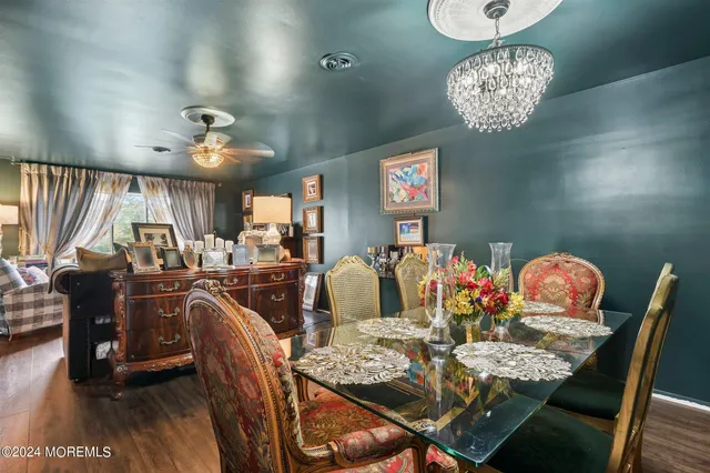 a view of a dining room with furniture a chandelier and wooden floor