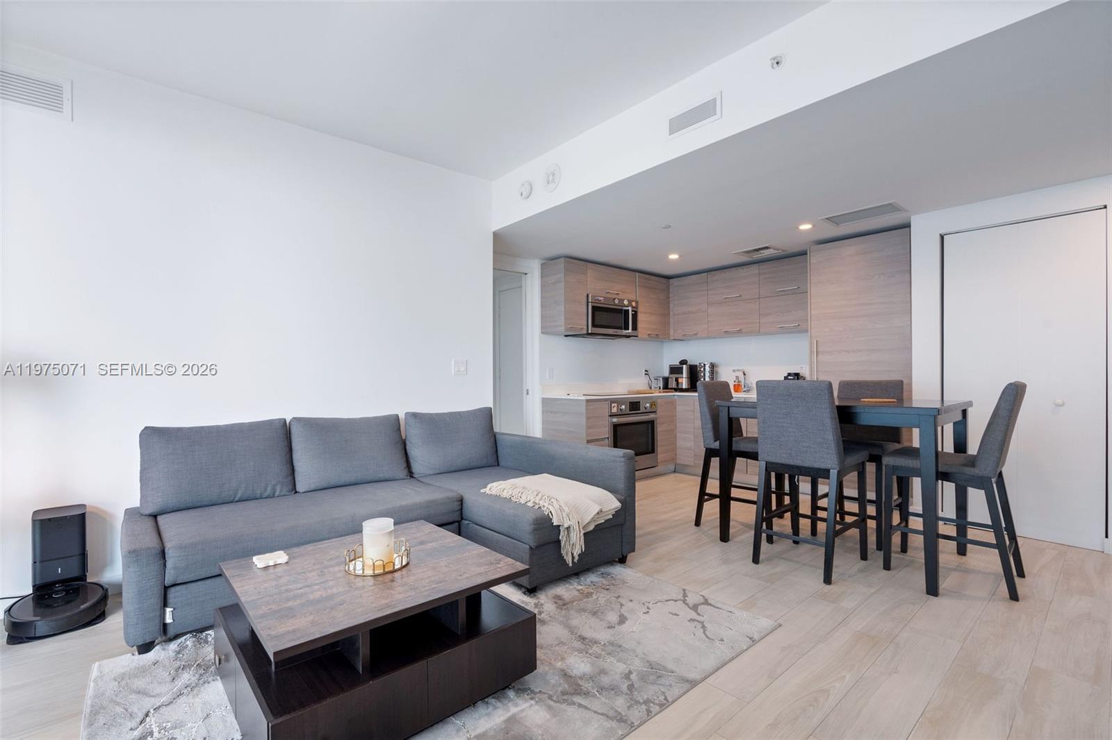 1300 South Miami Avenue, Unit 2807 Miami, FL 33130 - Photo 1 of 22 a living room with furniture and a dining table with kitchen view