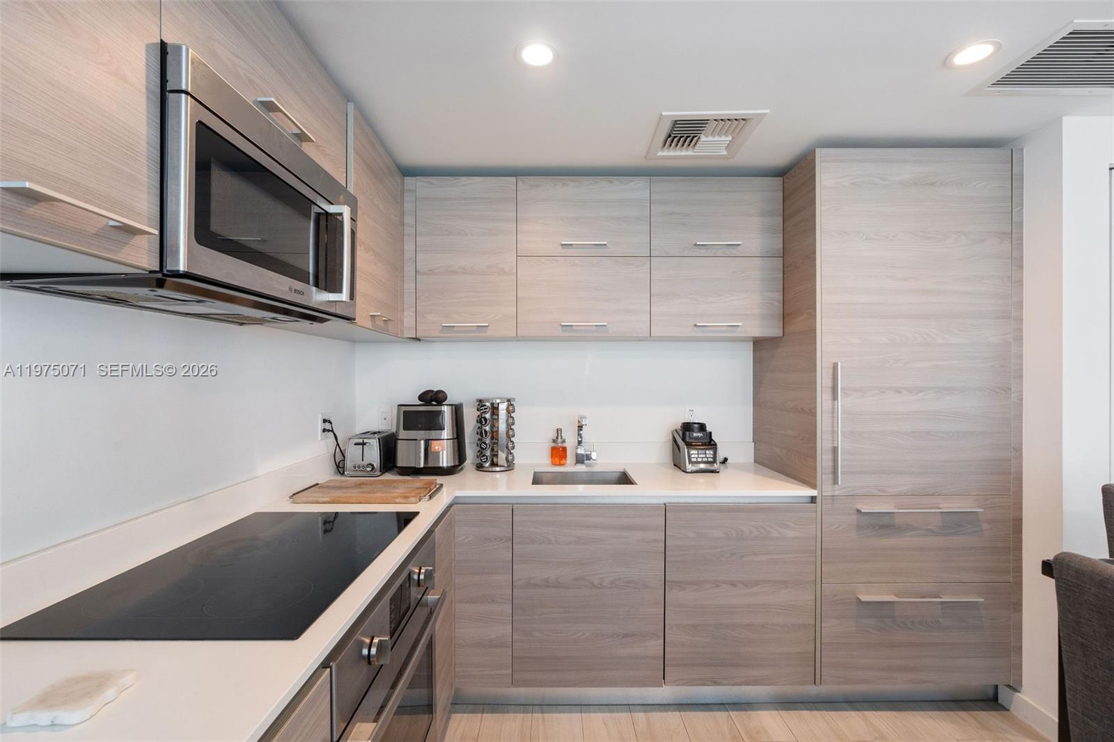 1300 South Miami Avenue, Unit 2807 Miami, FL 33130 - Photo 10 of 22 a kitchen with stainless steel appliances granite countertop a sink and a microwave