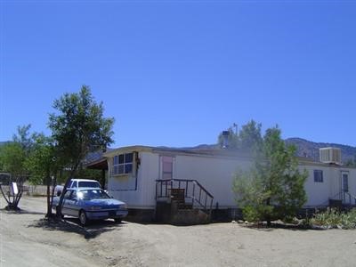 2302 Trinity Road Pinon Hills, CA 92372 - Photo 1 of 1 a front view of a house with cars parked
