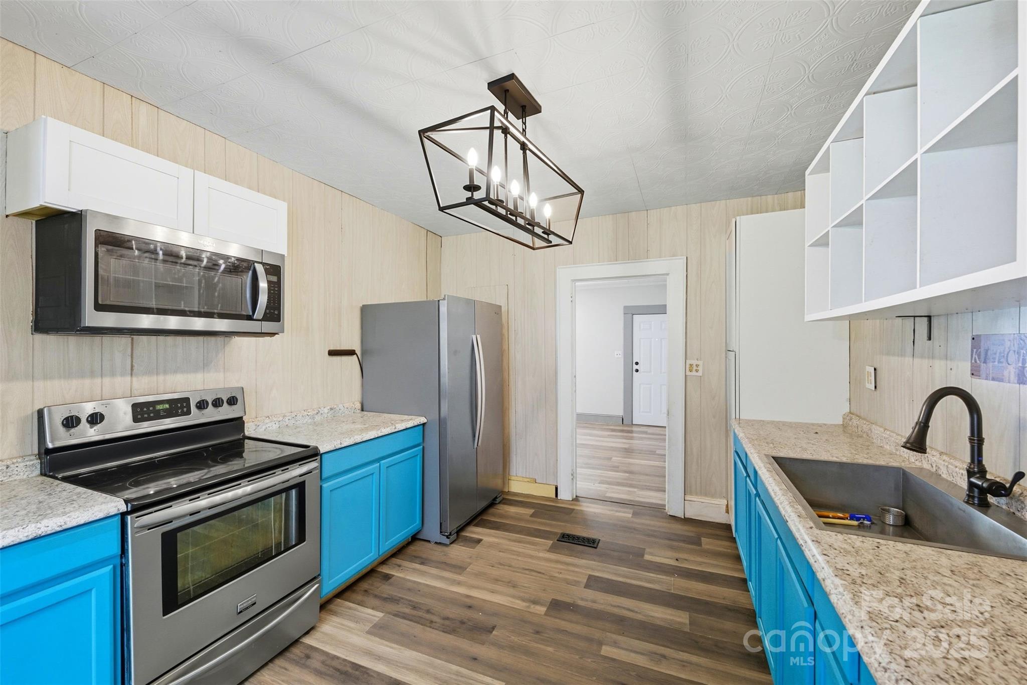 a kitchen with stainless steel appliances granite countertop a stove refrigerator and microwave
