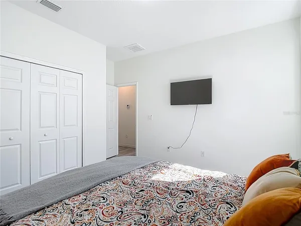 a bedroom with a bed and a flat screen tv