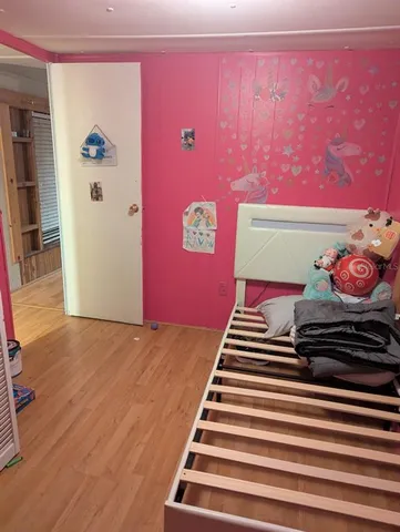 a bedroom with a bed and wooden floor