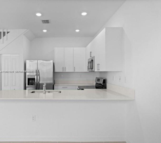 701 Southeast 14th Court Homestead, FL 33034 - Photo 6 of 18 a kitchen with stainless steel appliances sink refrigerator and microwave