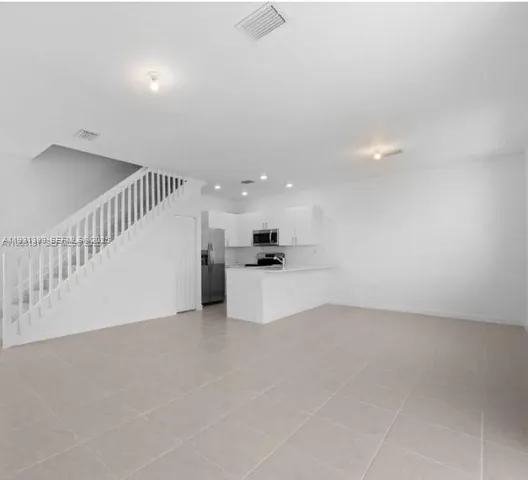 a view of kitchen with white cabinets and wooden floor