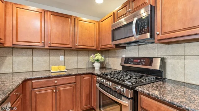 a kitchen with granite countertop cabinets stainless steel appliances and a counter space