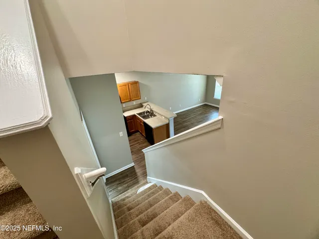 a view of a hallway with wooden floor and staircase