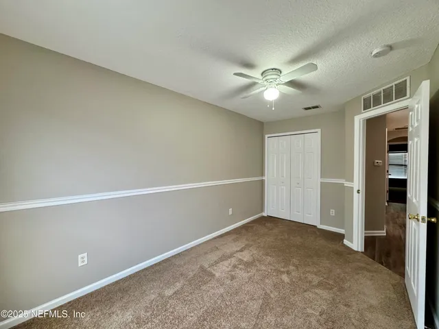 an empty room with a ceiling fan and a window