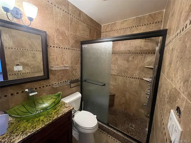 a bathroom with a granite countertop sink mirror vanity and toilet